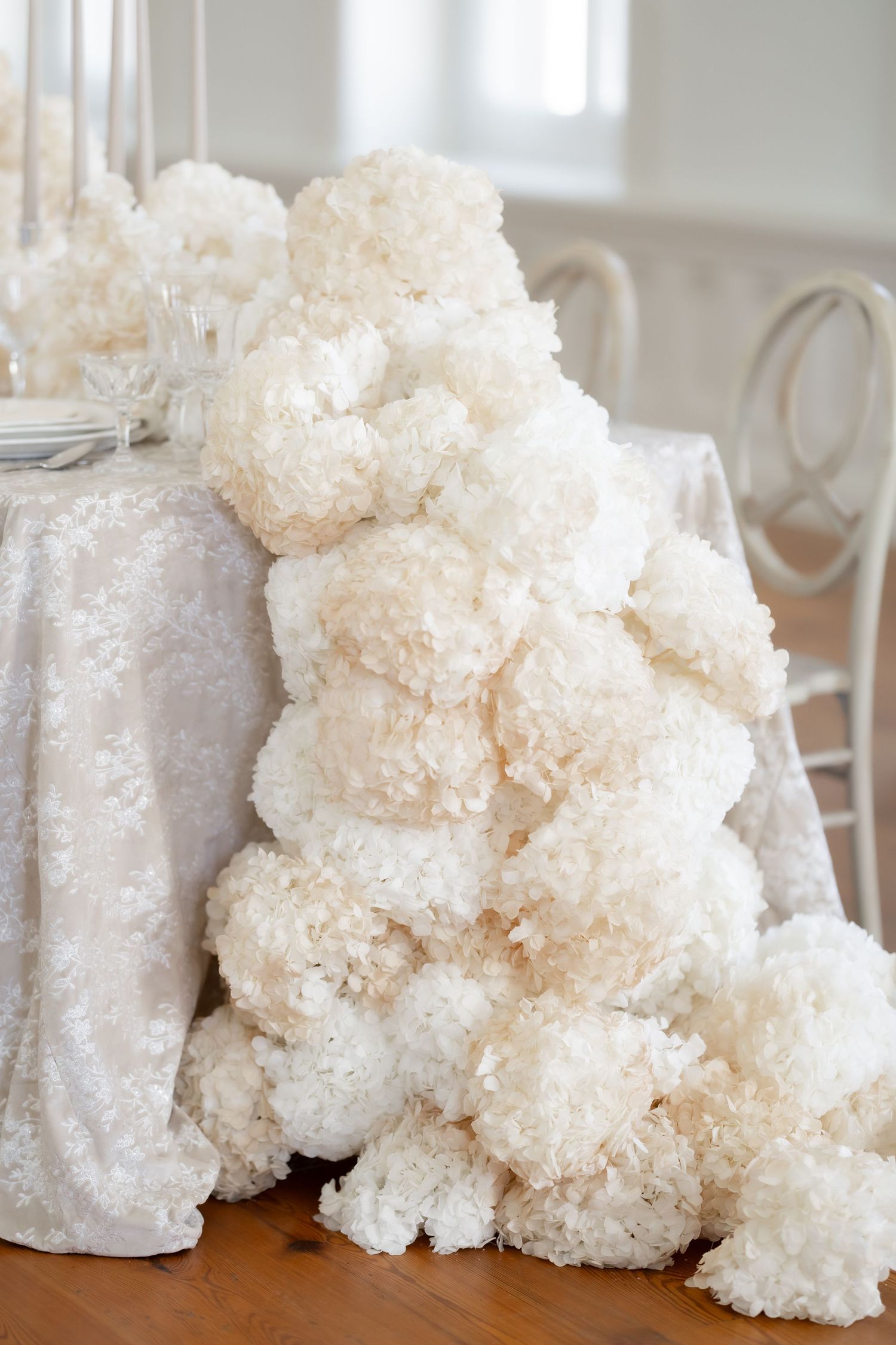Textured white flowers arranged on wedding reception table.