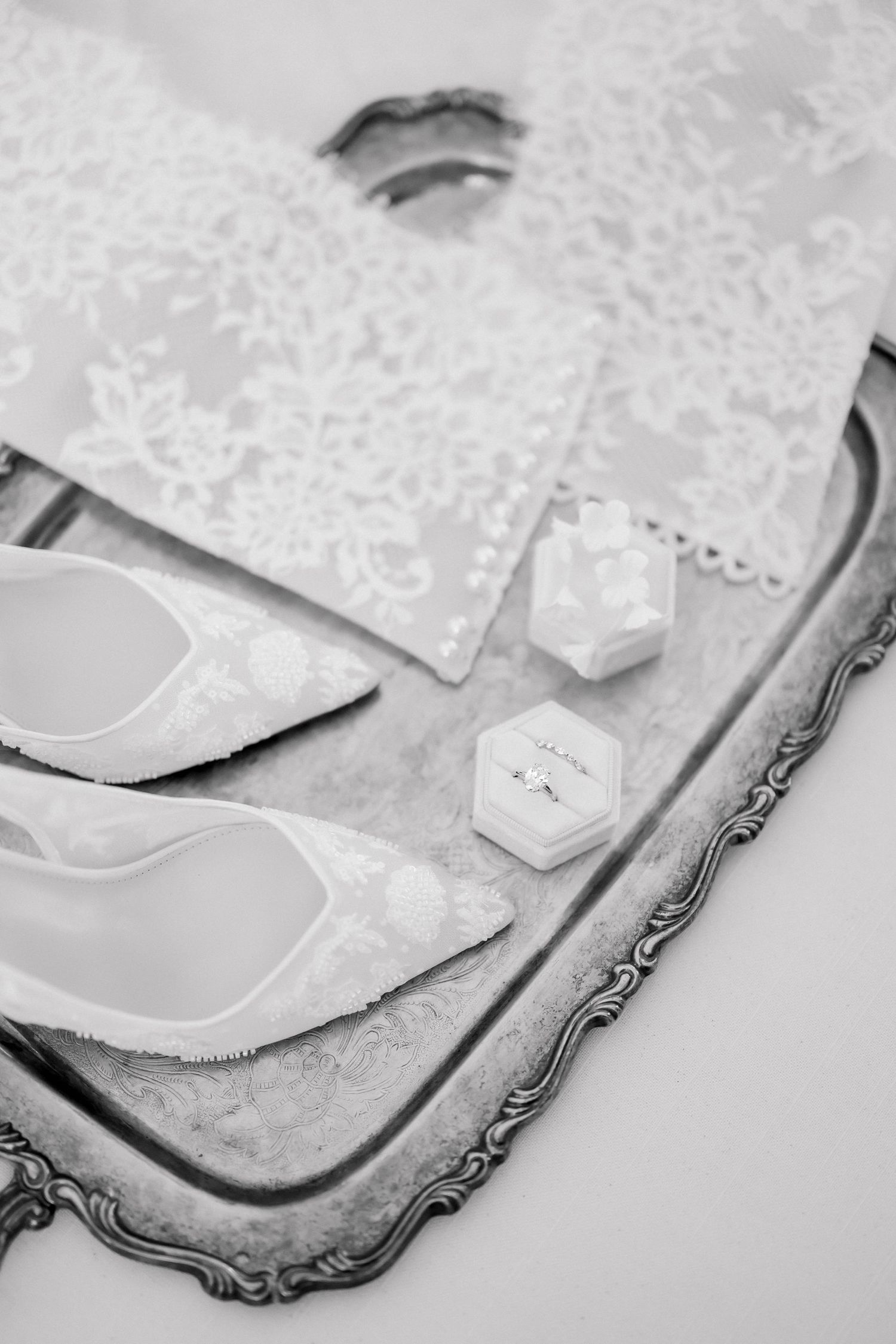 Ornate silver tray with delicate lace patterns and decorative details in black and white.