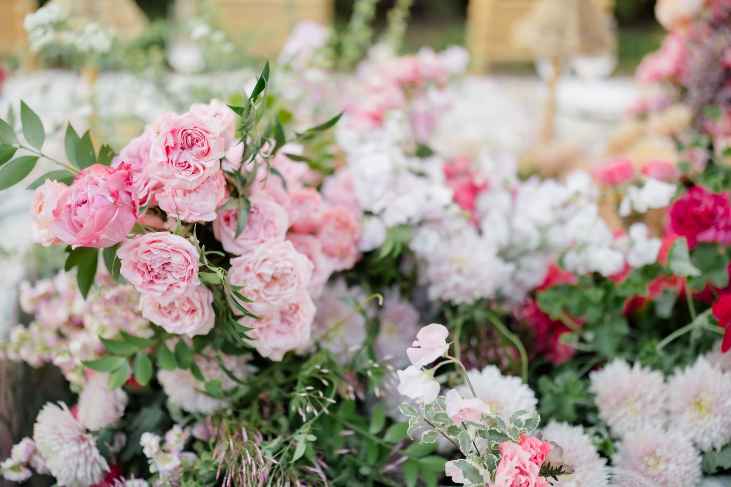 Close-up of pink and white floral centerpiece with roses and mixed flowers.