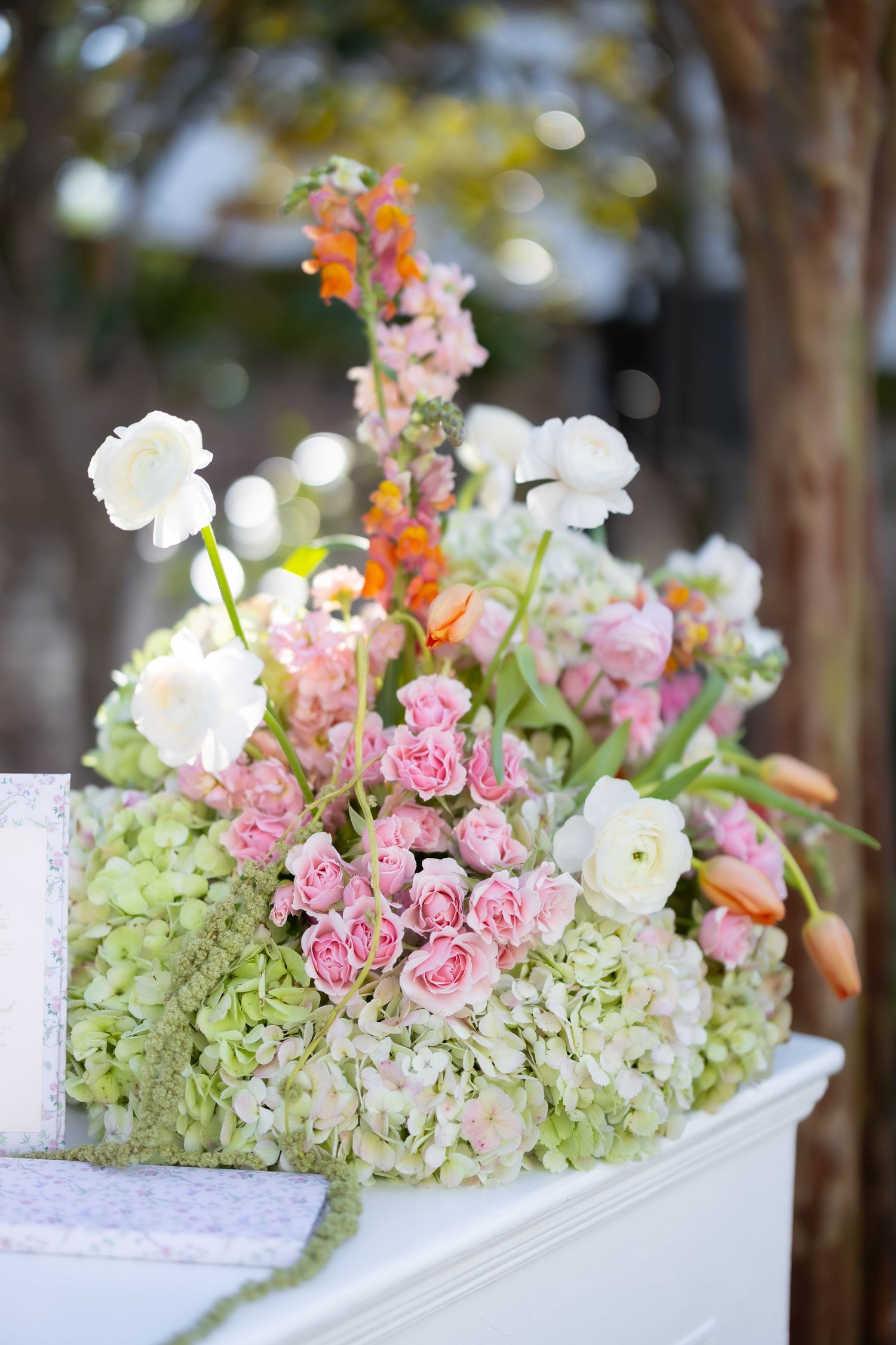Lush floral arrangements featuring pink roses and white hydrangeas on display.