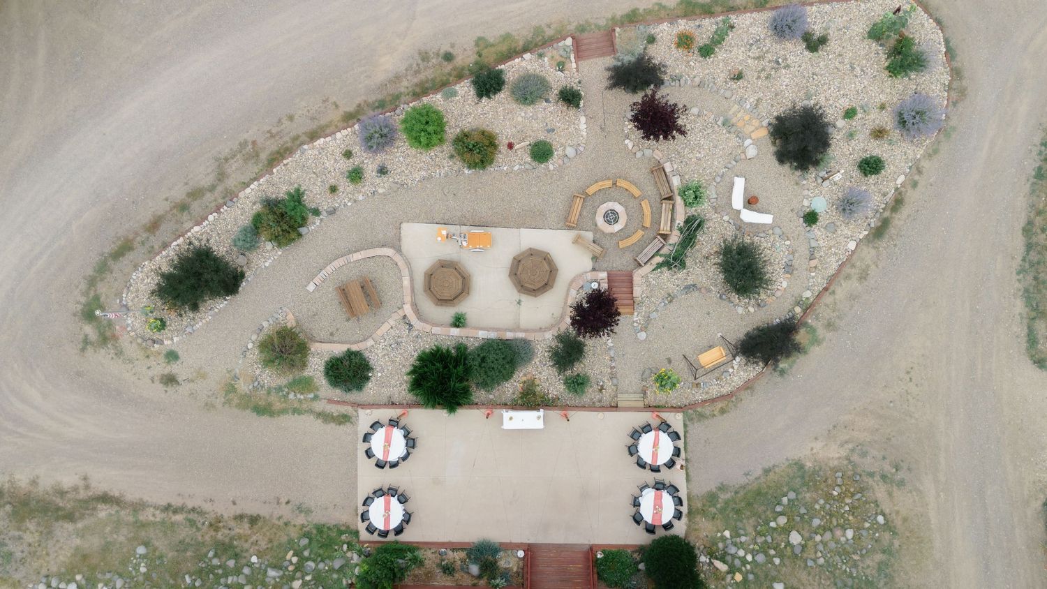 Aerial view of a desert landscape garden with circular features, drought-resistant plants, and an outdoor seating area.