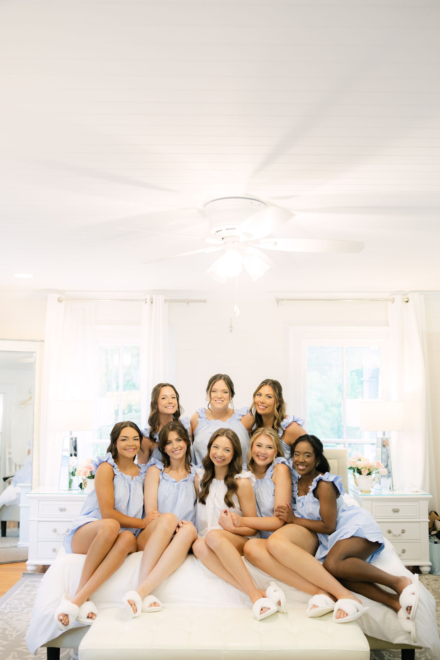 Getting ready portrait of bride with her bridesmaids in matching pajamas.