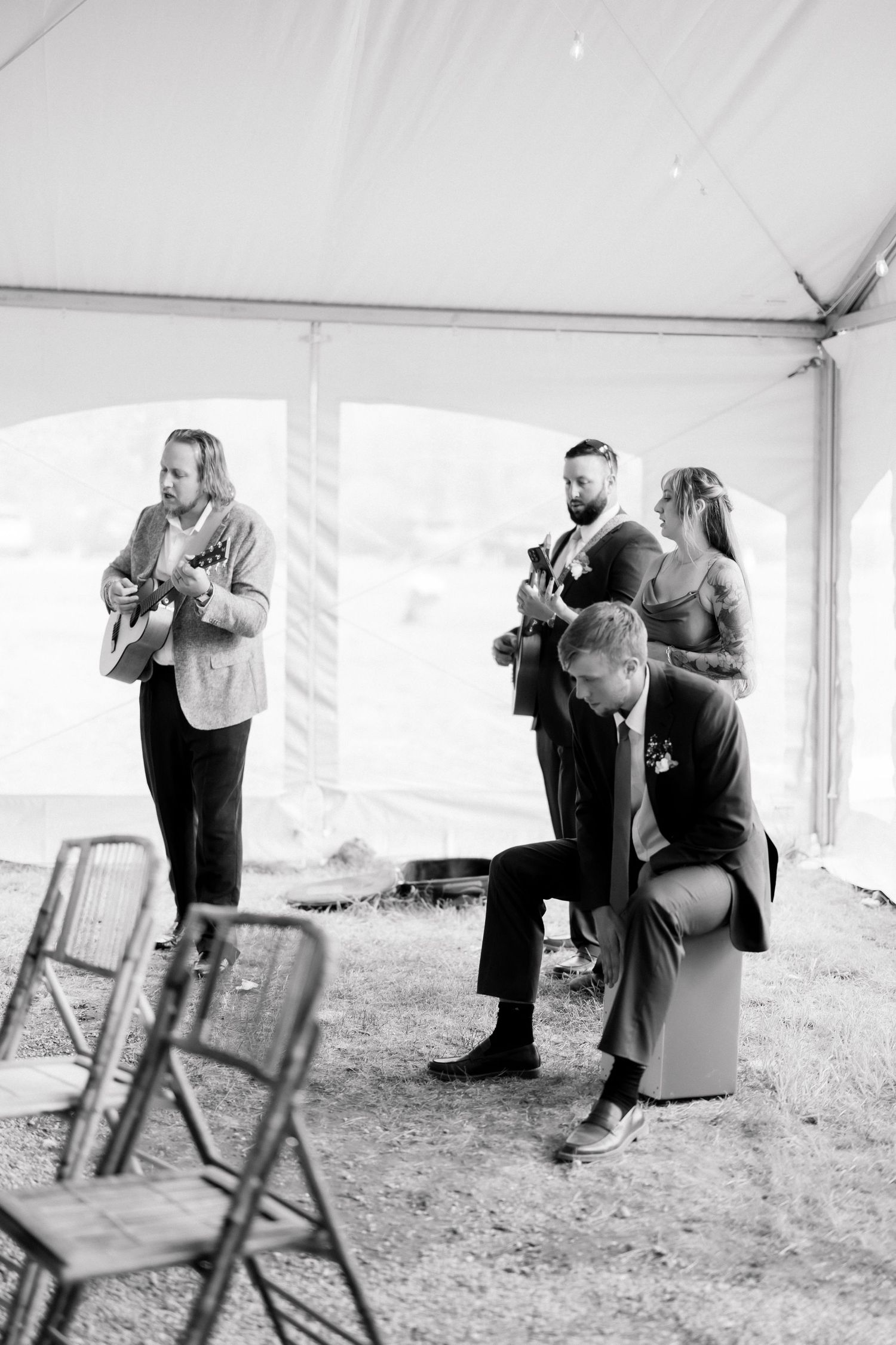 Black and white photo of live musicians performing acoustic guitars at wedding reception.