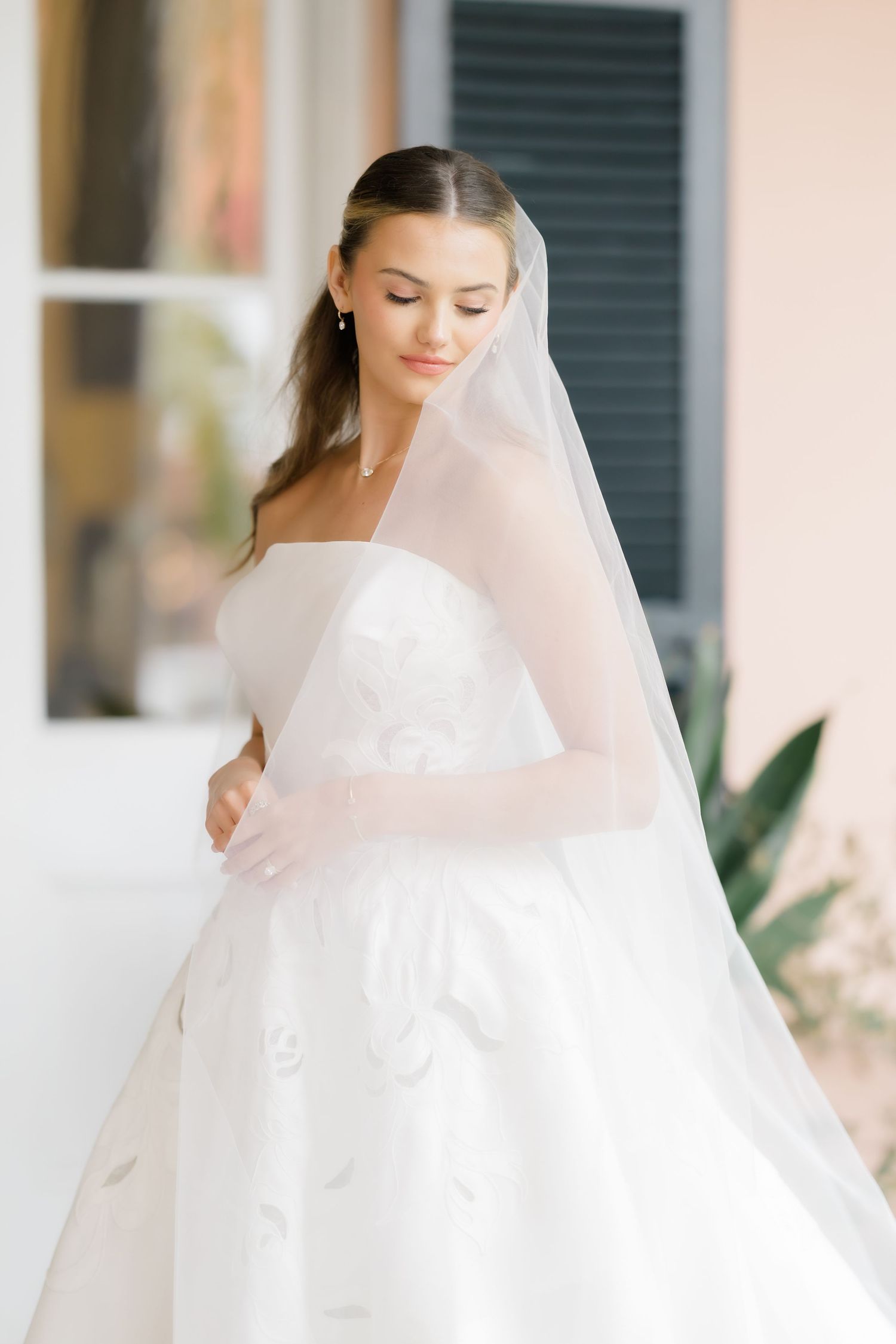Ethereal white wedding dress with flowing veil in natural light at The Parsonage in Charleston, South Carolina.