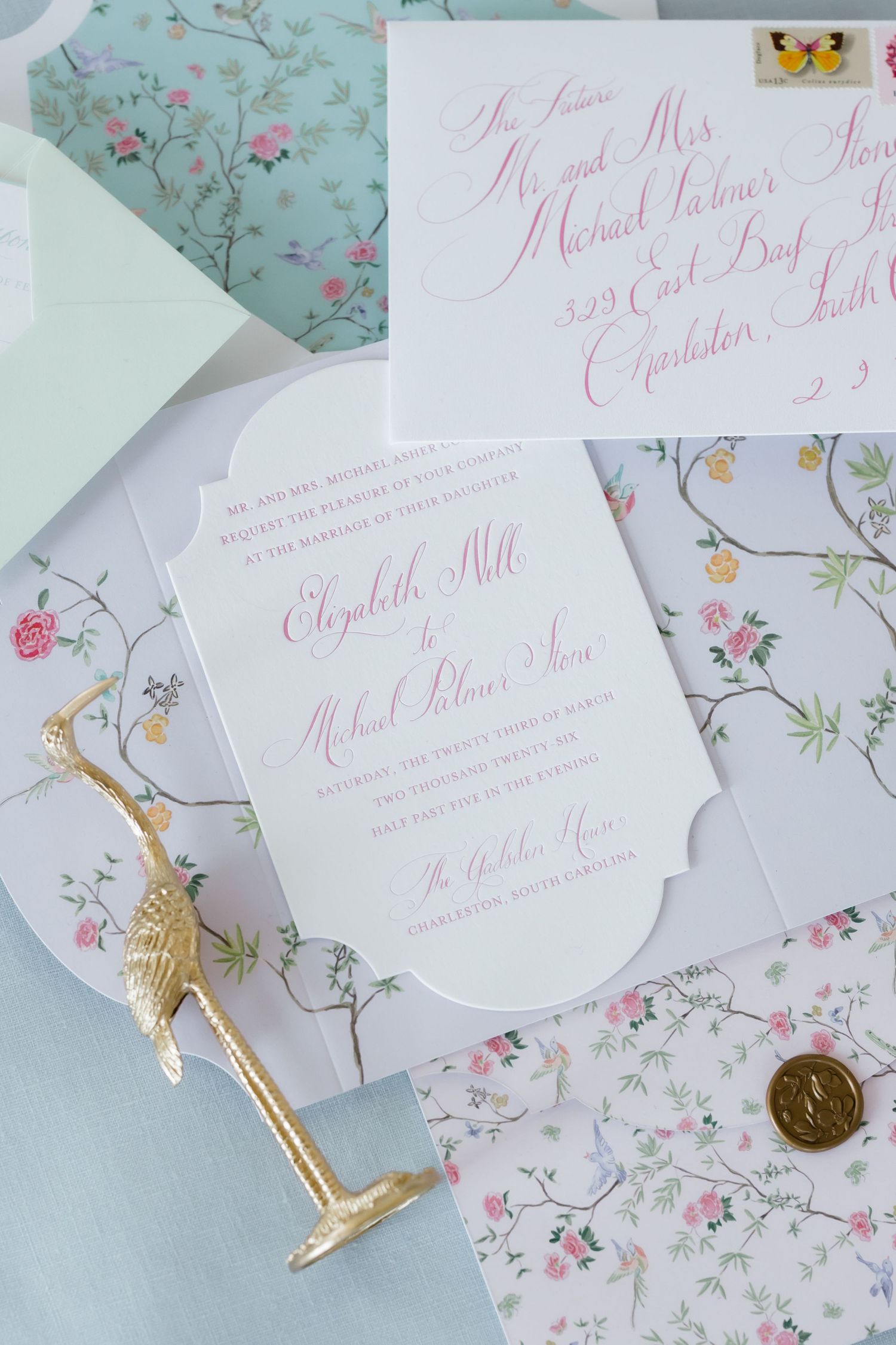 Elegant wedding invitations with pink calligraphy with floral envelope liner with decorative gold accents.