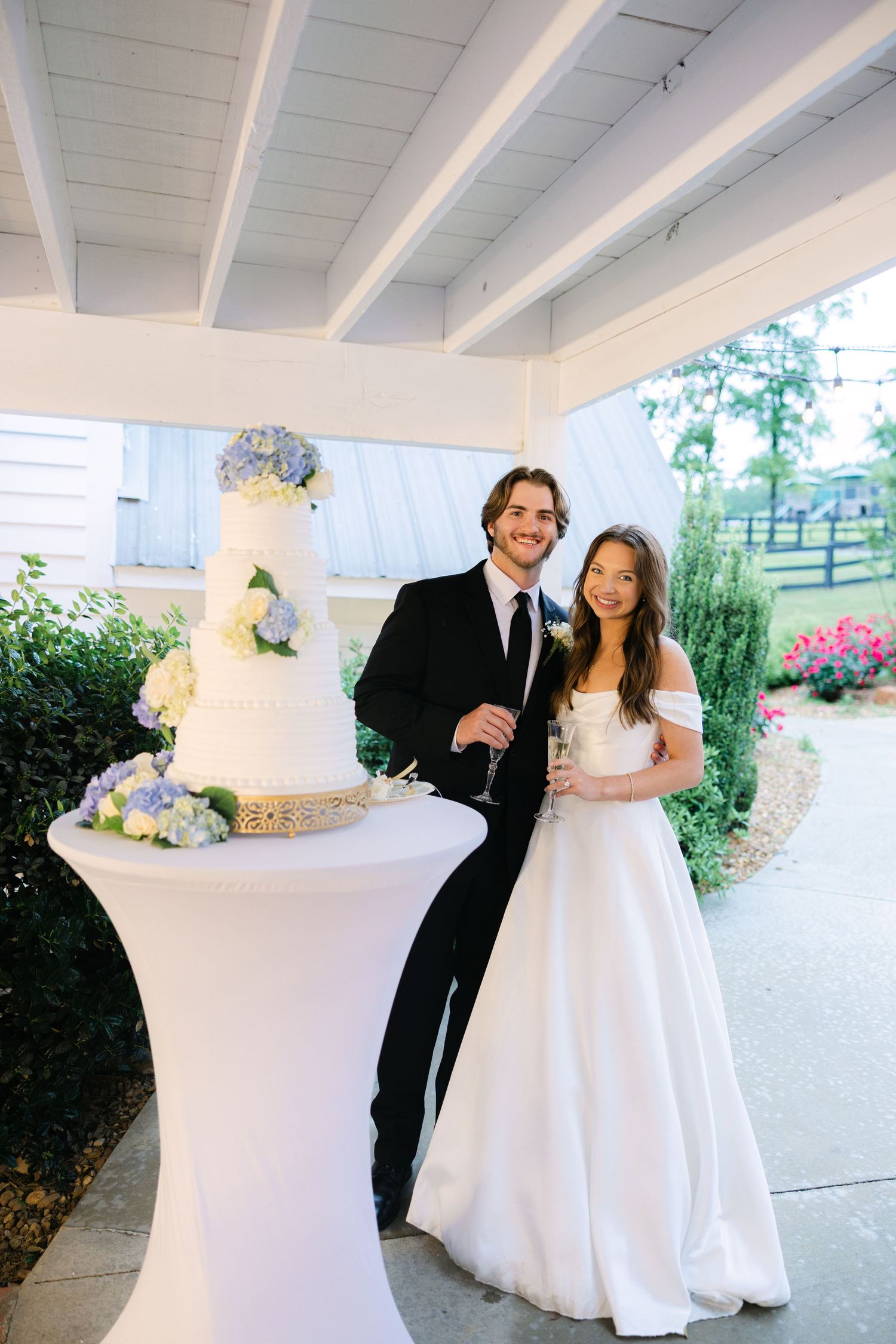 Bride and groom cake cutting with classic floral wedding cake