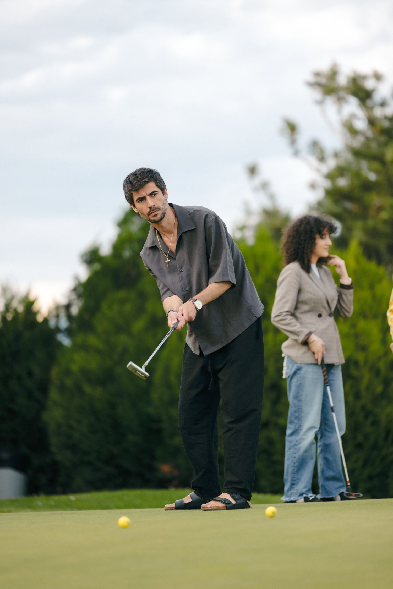 Golfers putting on a green course during a casual game.