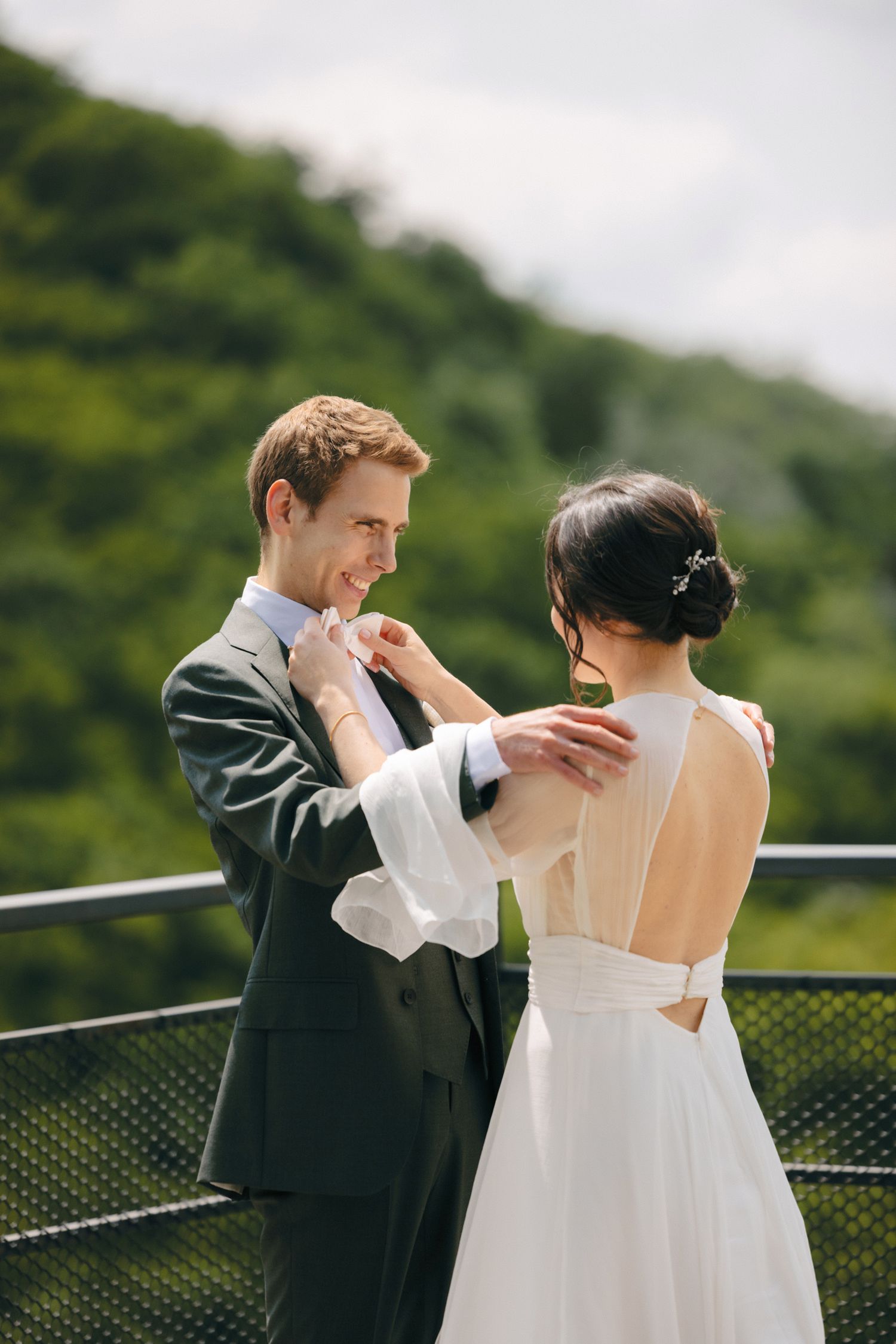 Couple sharing an intimate moment on an outdoor deck surrounded by lush greenery.