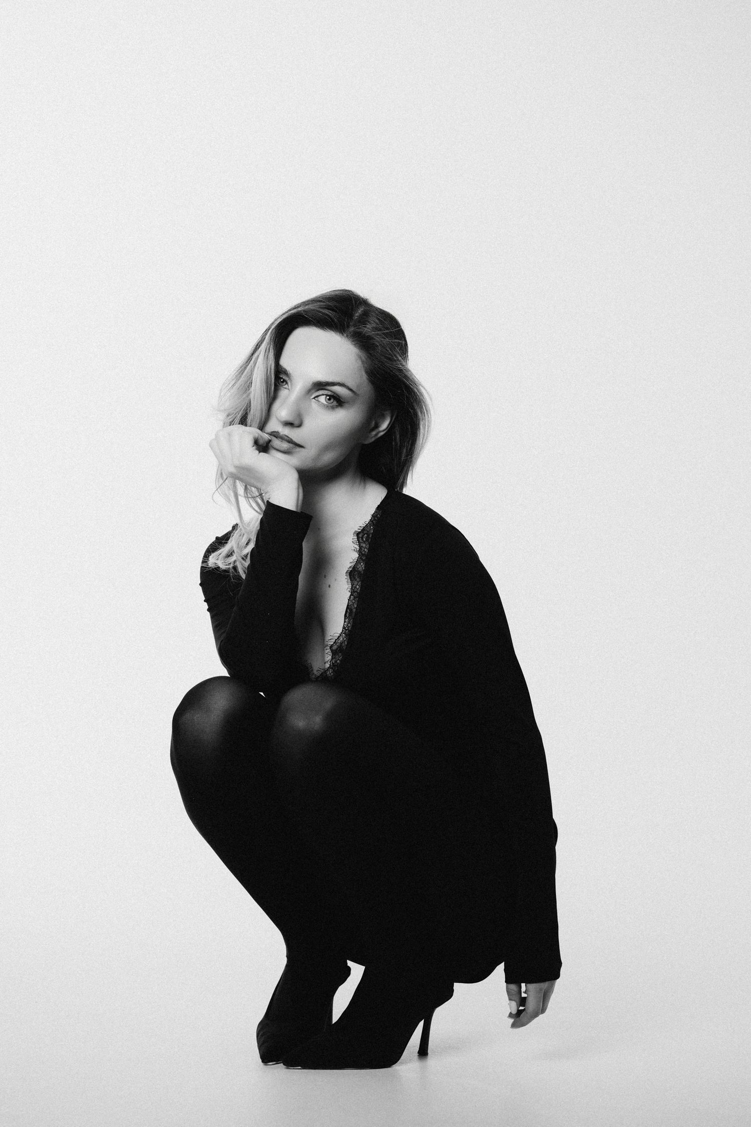 Artistic black and white portrait series showing dynamic poses against white backdrop.