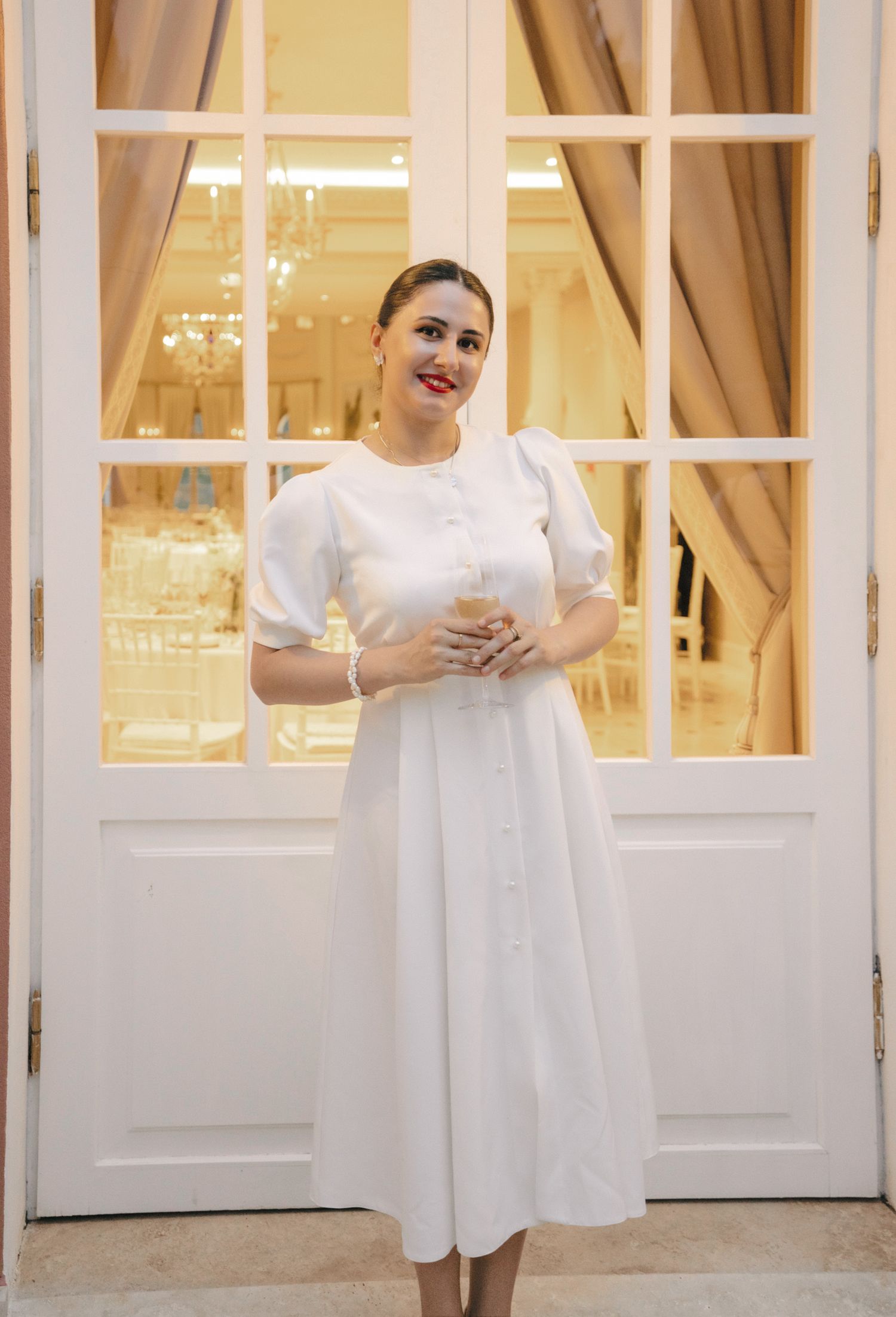 White French doors frame an elegant interior scene with warm lighting.
