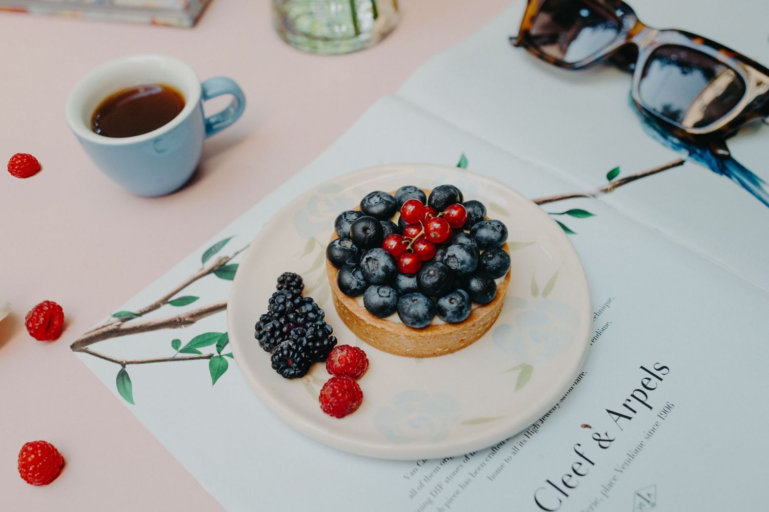 Fresh berries and pastries arranged on white plates with delicate floral accents.