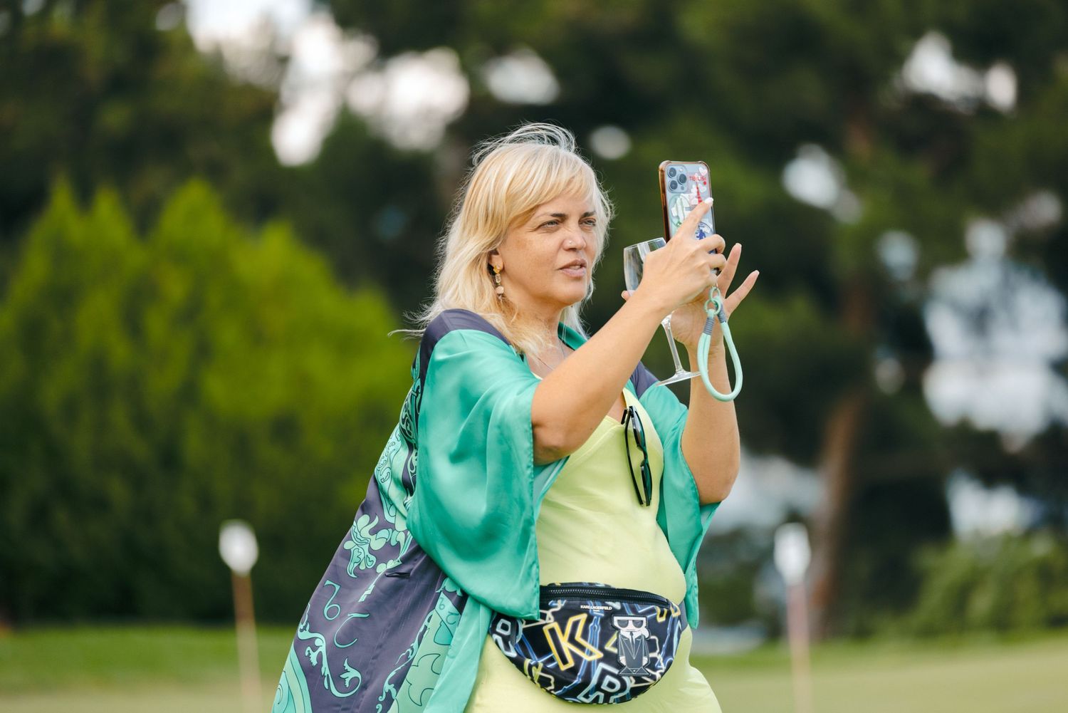 Attendees use phones to capture photos at an outdoor gathering.