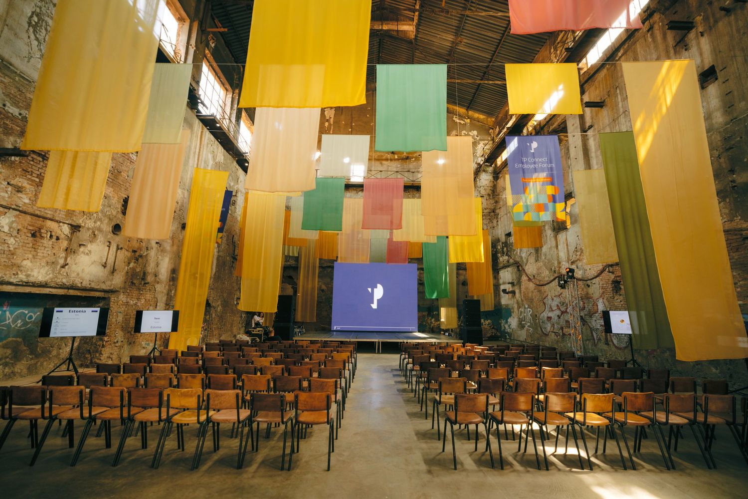 Large event space with organized seating and multicolored wall panels.