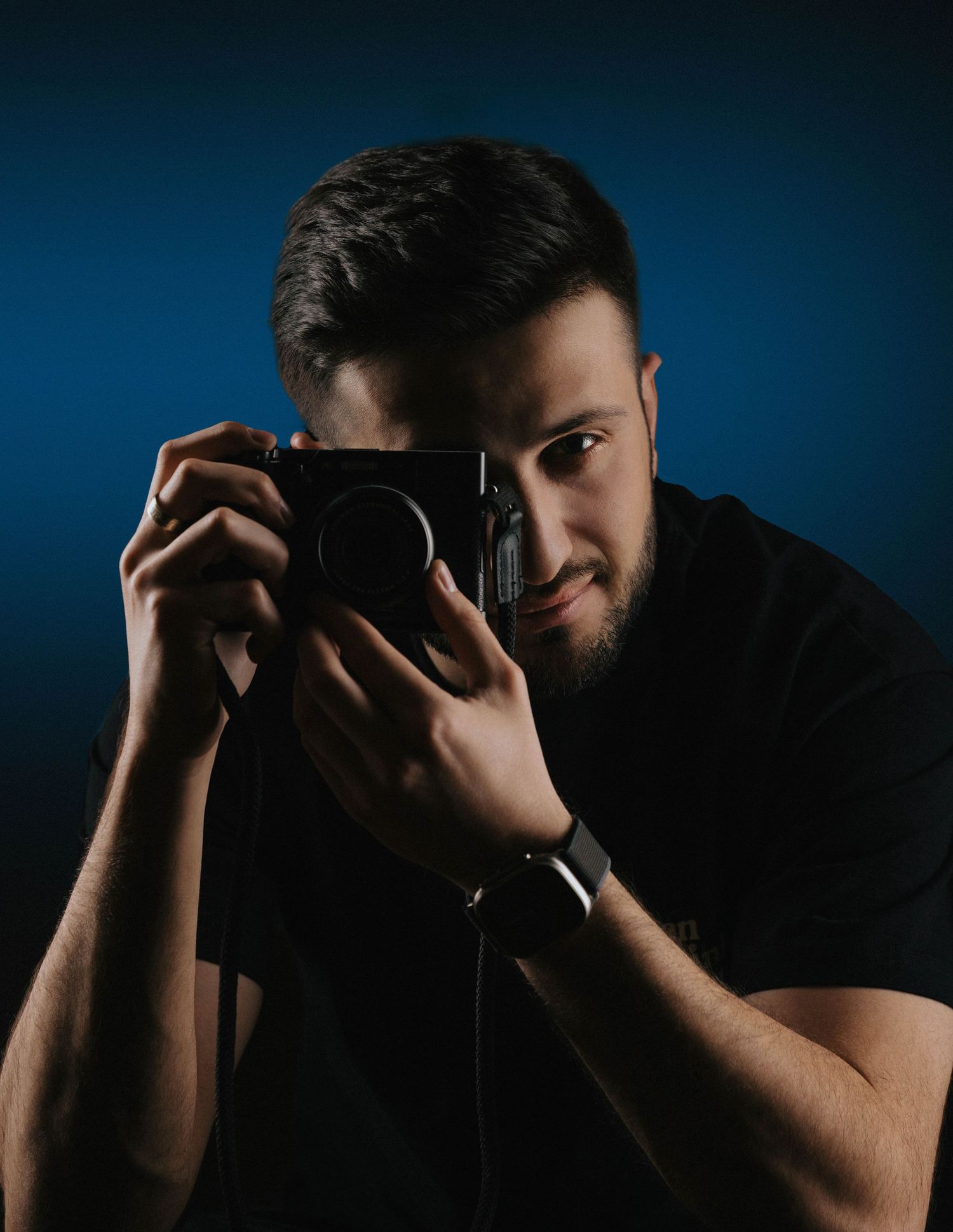 Dramatic low-key portraits with shadowy lighting against dark blue background.