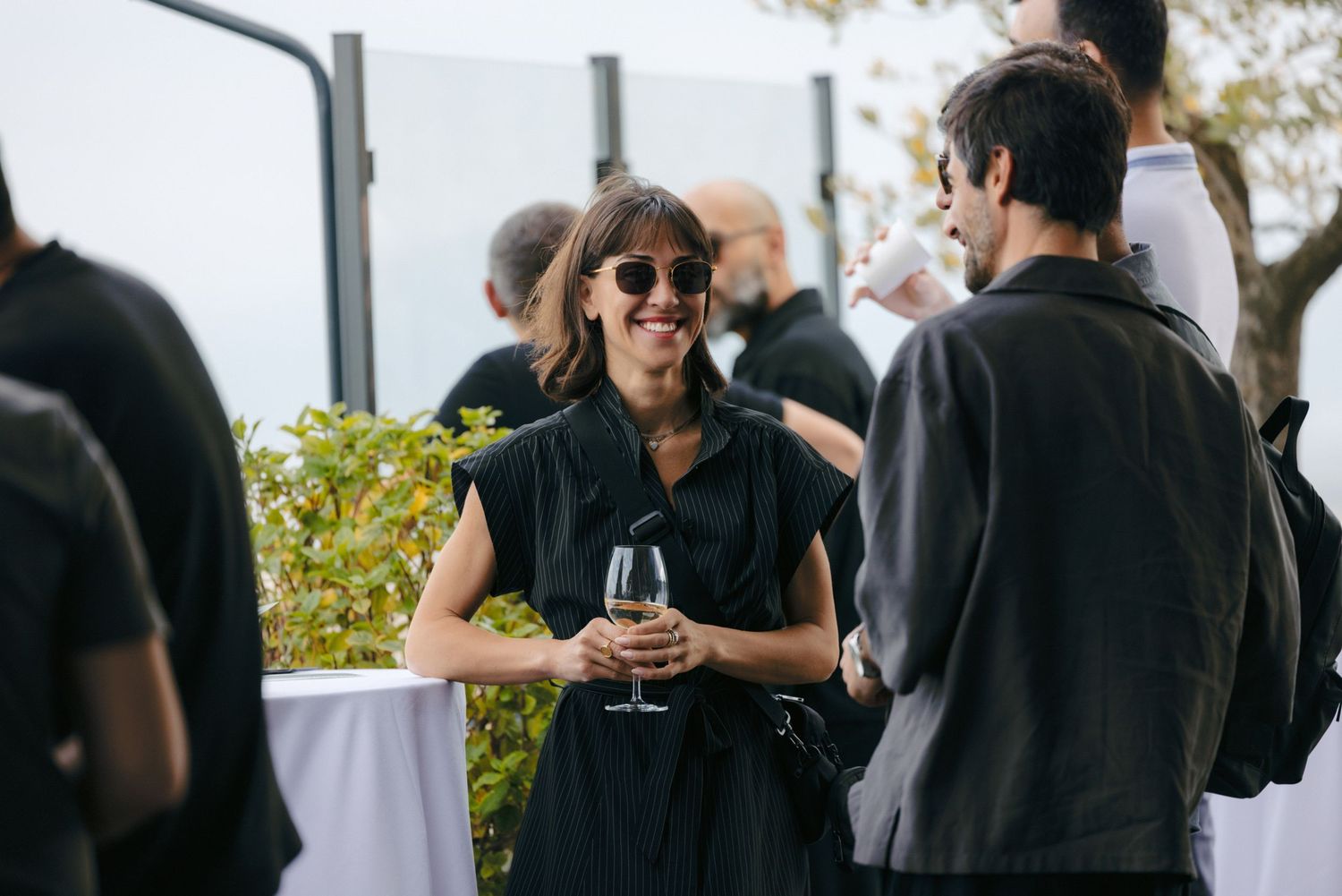 Guests mingle and socialize at an outdoor covered reception area.