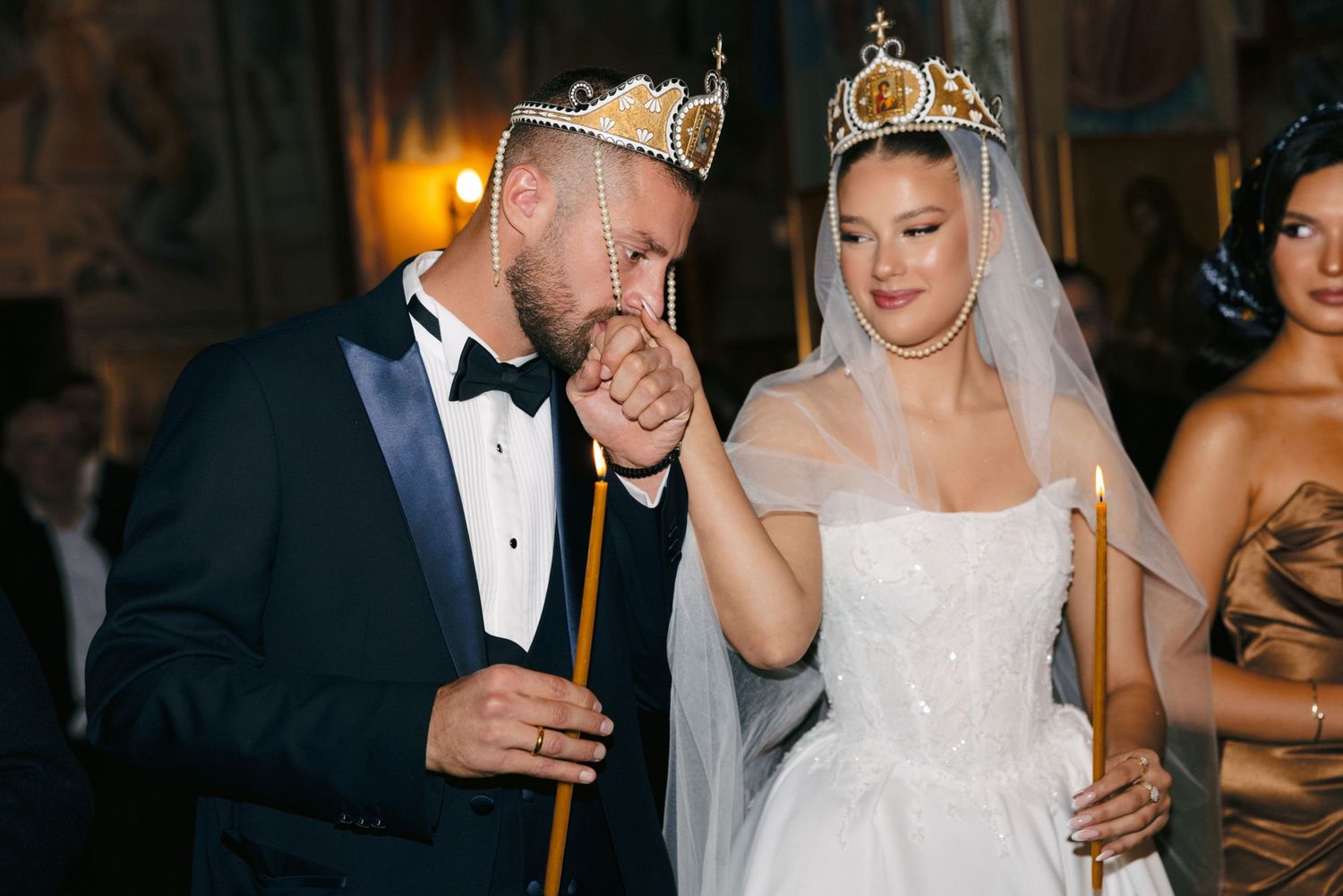 Wedding couple wearing crowns during traditional Orthodox marriage ceremony.