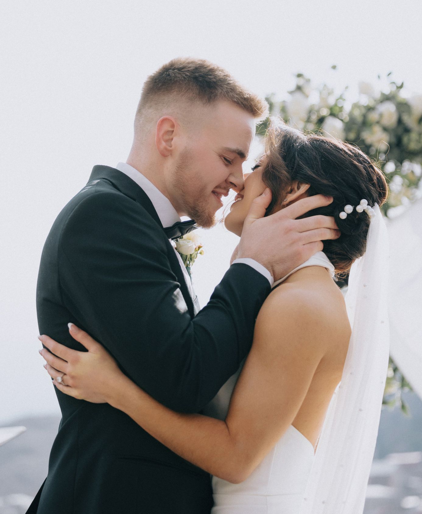 A tender moment shared between newlyweds embracing outdoors on their wedding day.