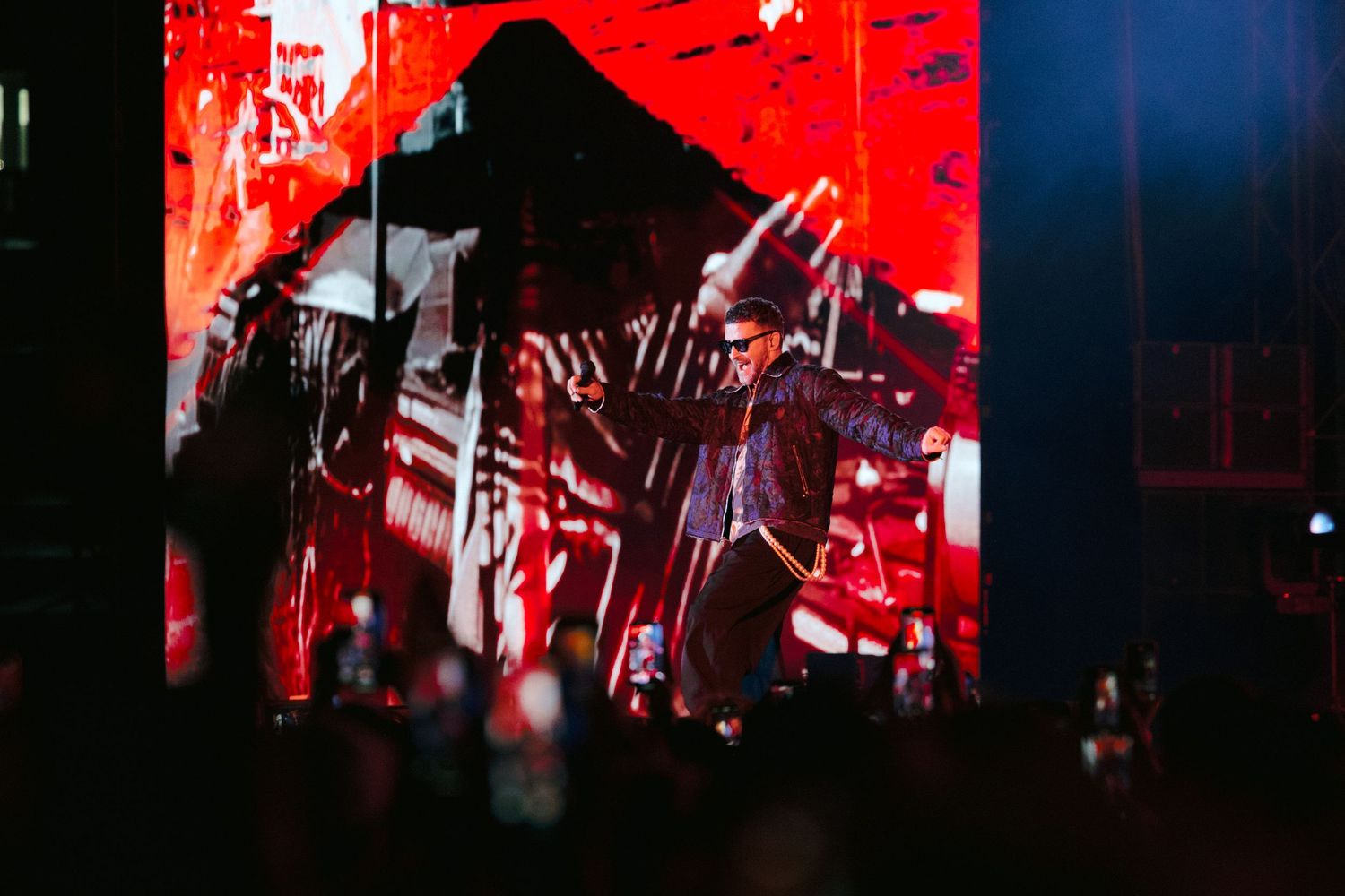 Concert stage with dramatic red lighting effects and fog creating an atmospheric performance scene.