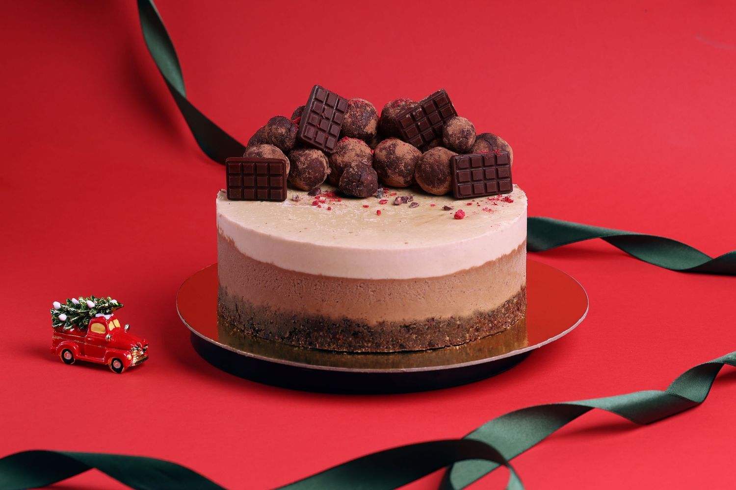 Series showing chocolate cake with truffles and decorative elements on red background.