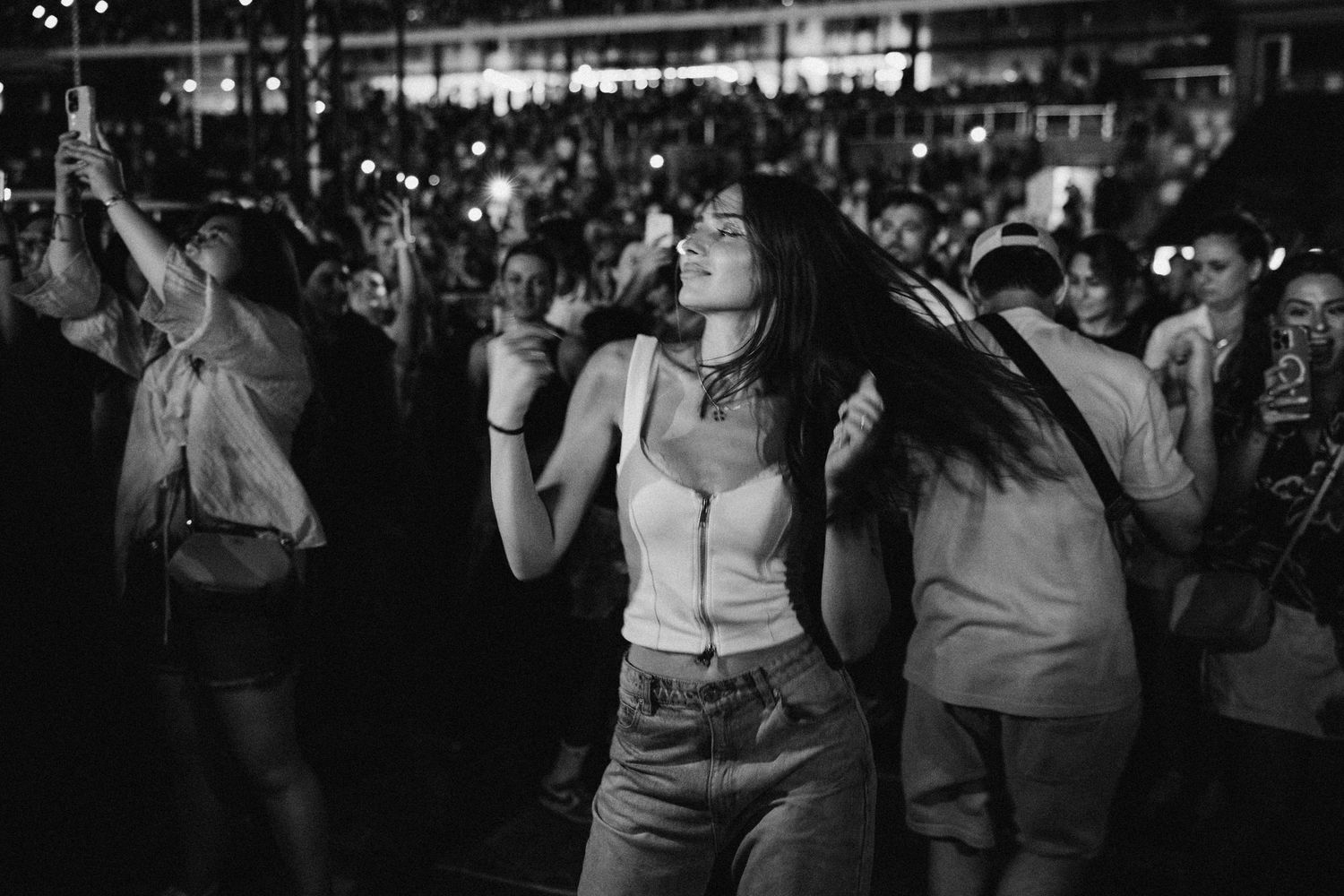 Concert crowd enjoying live music performance in black and white.
