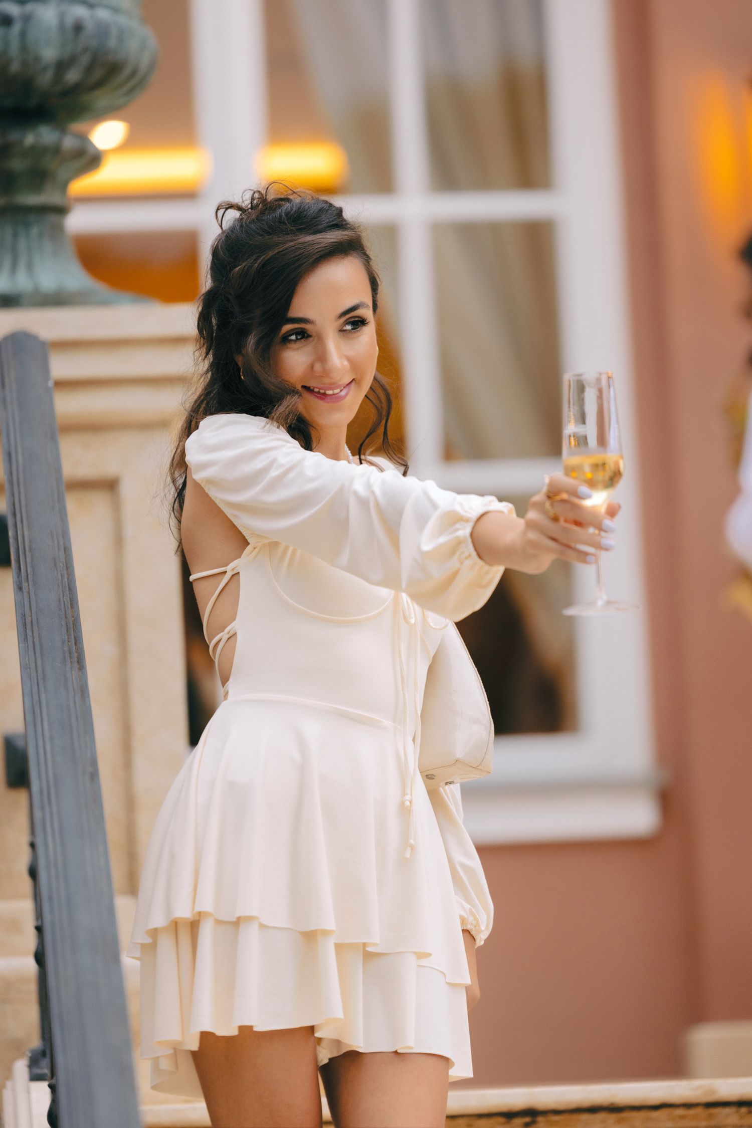 Elegant dance performance in white dress against vintage building backdrop.