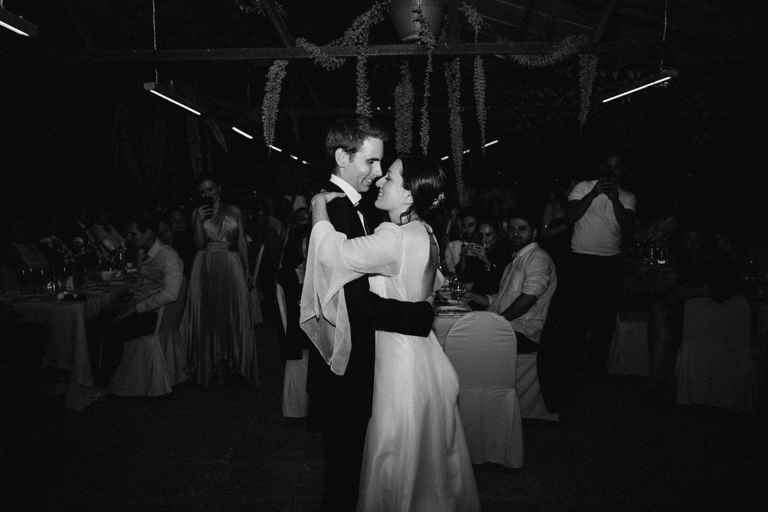 Wedding guests dancing and celebrating on a dark dance floor at night.