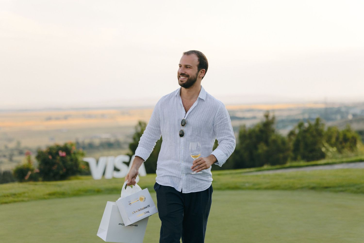 Event guests mingling on a scenic hilltop overlooking a valley.