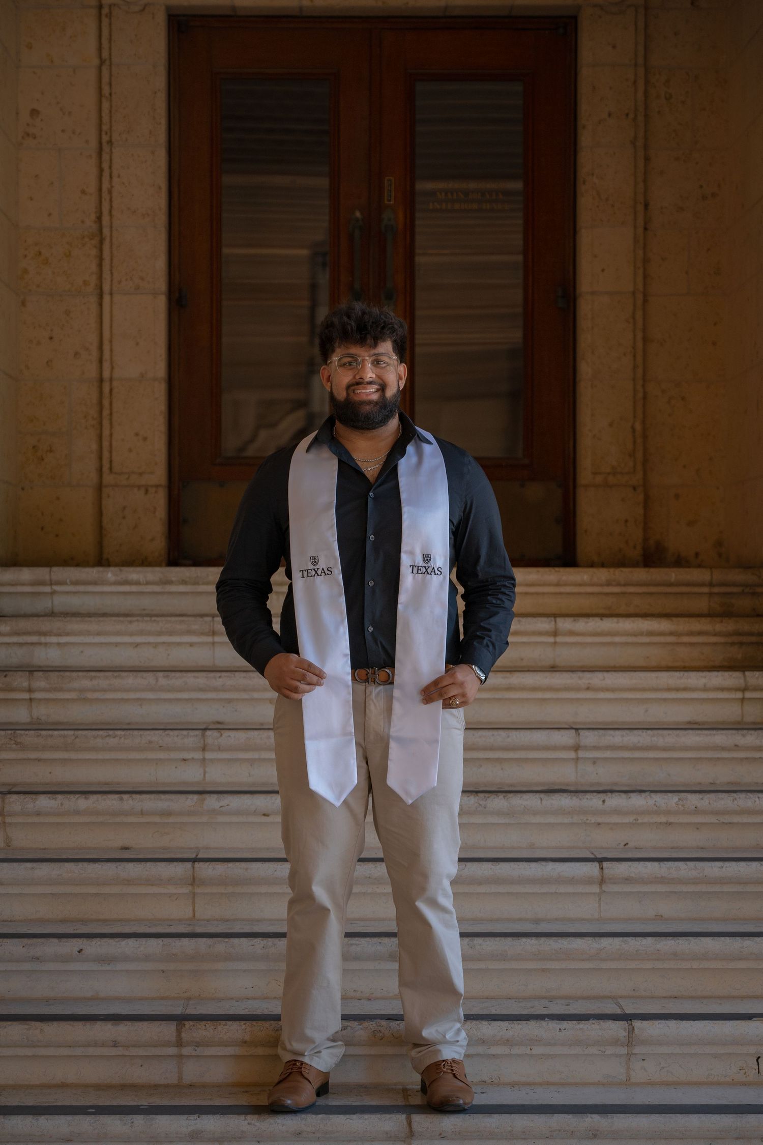 A series of photos showing someone in a black shirt and white vest posing in front of stone columns.