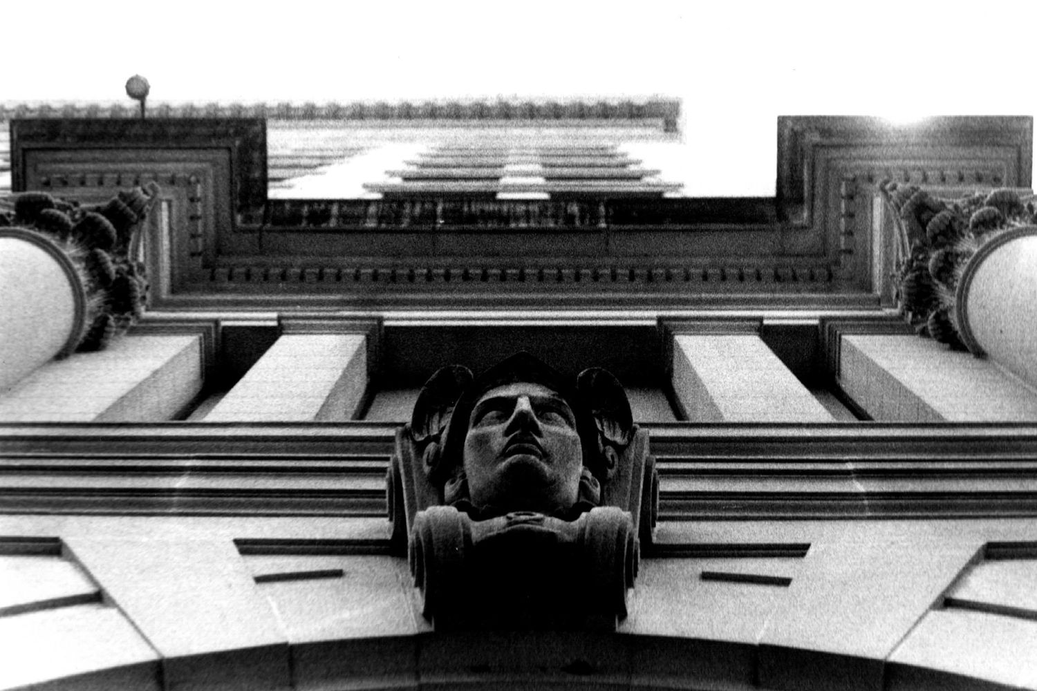 Architectural detail of ornate classical building columns and moldings in black and white.