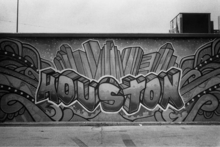 Long concrete wall covered in black and white graffiti art.