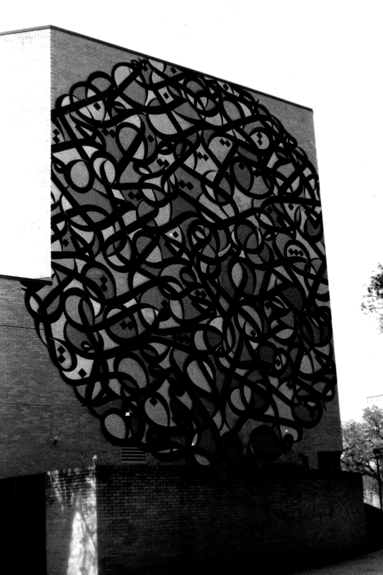 Arabic calligraphy meets modern graffiti on the sidewall of a building at the University of Houston.