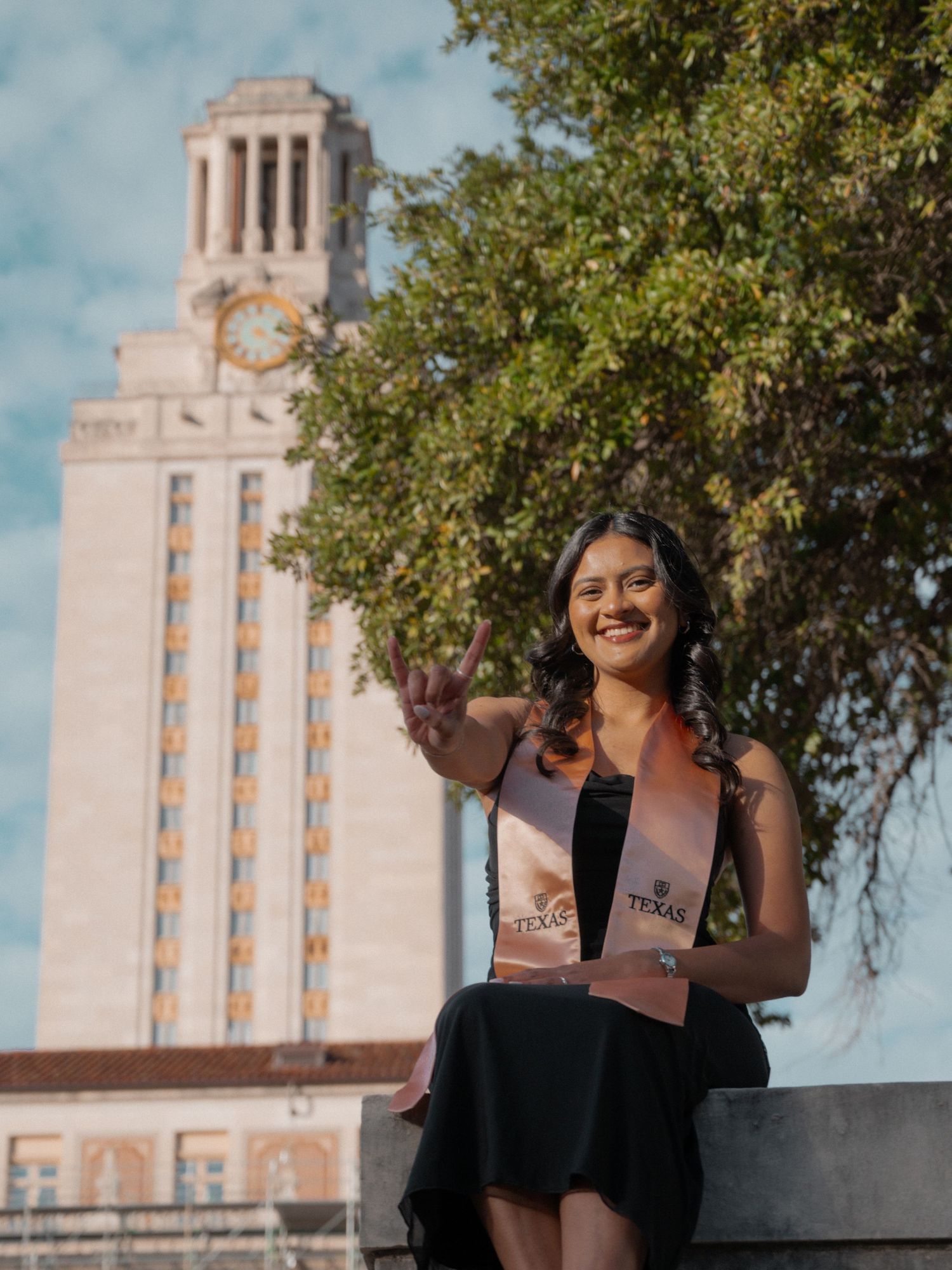 A graduation photoshoot series featuring a student posing in front of the iconic UT Austin Tower on a sunny day.