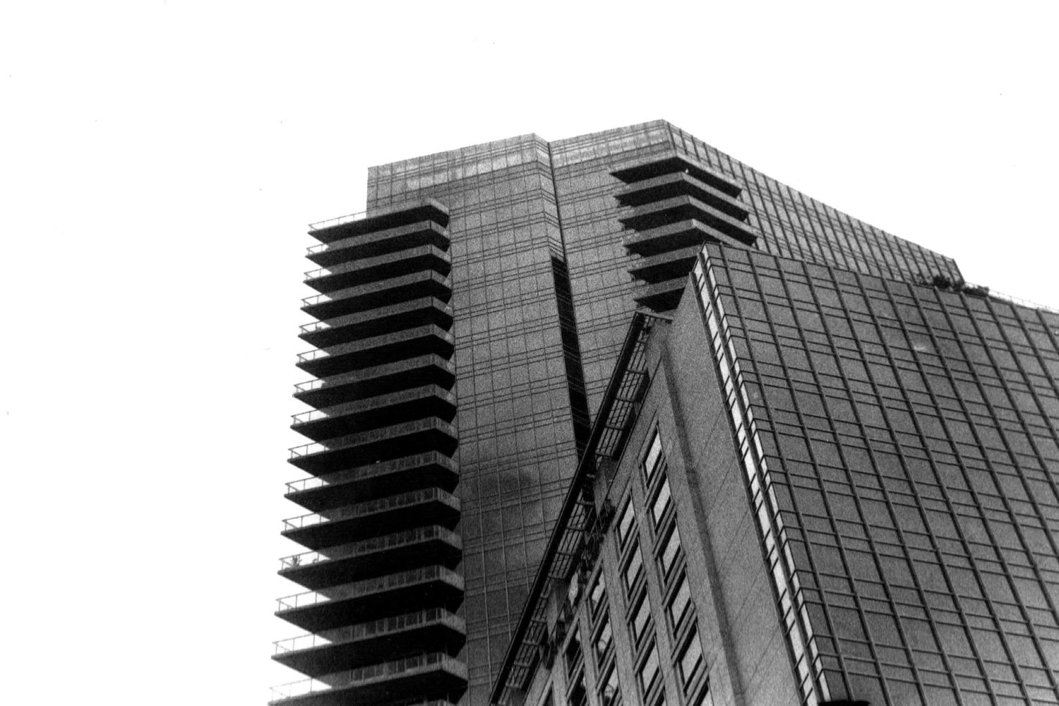 Modern glass skyscraper with angular architectural details photographed from below.