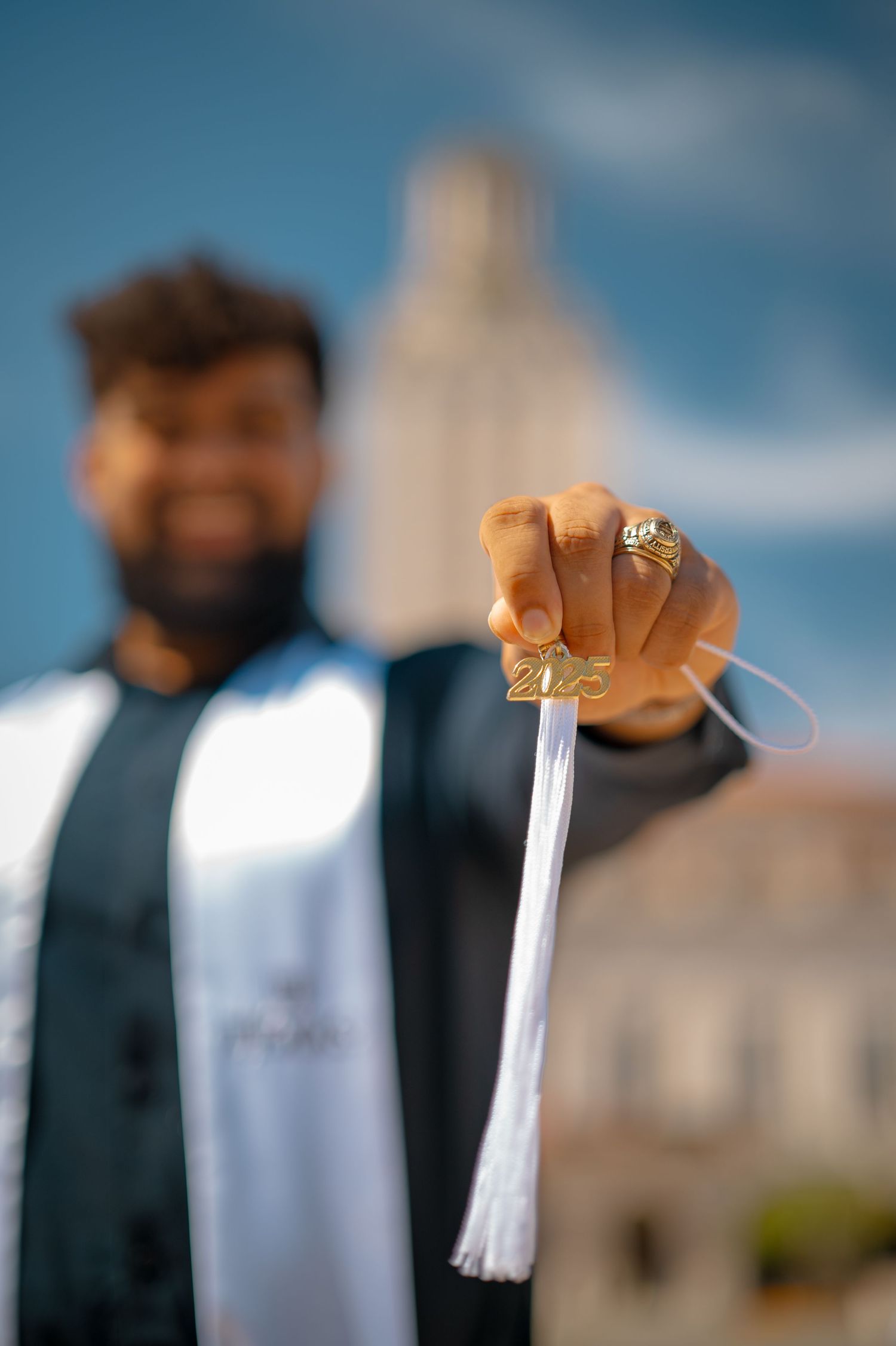 Graduation stole and class ring displayed with UT Tower in soft focus background.