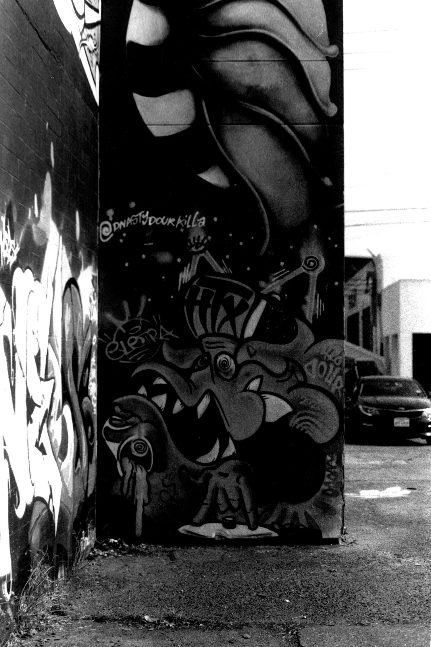 Urban graffiti art covers a dark concrete wall in bold abstract designs.