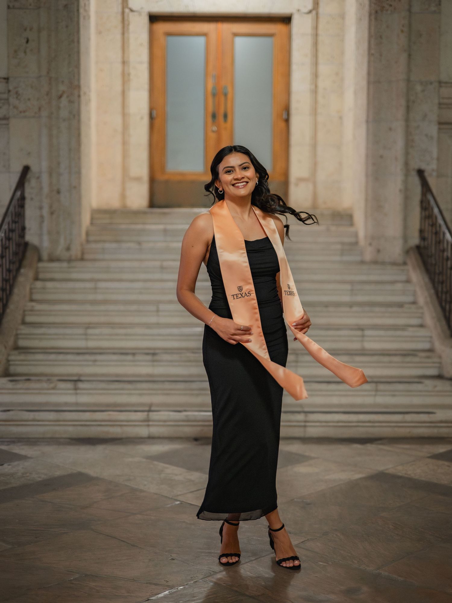 A sequence of five photos showing a person in a black dress dancing joyfully on stone steps of a historic building.