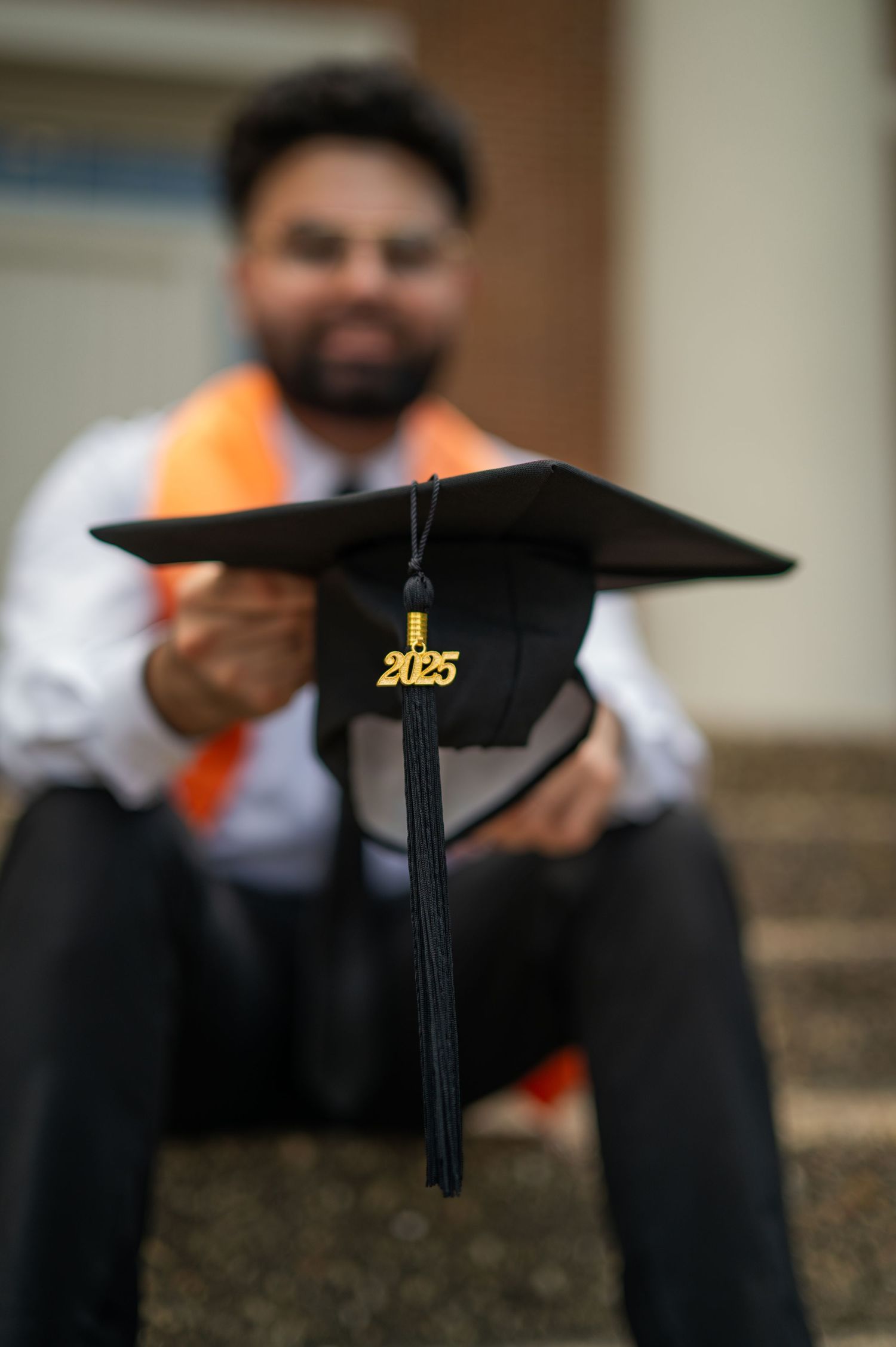 Graduation cap with 2023 tassel displayed on stone surface during graduation photoshoot.