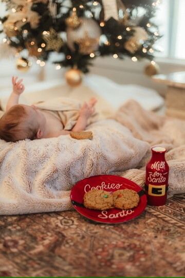 Indoor lifestyle family photography session with baby under Christmas tree next to Santa's milk and cookies in Omaha, Nebraska