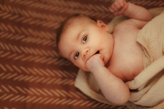 Baby boy in crib from family lifestyle photography session in Omaha, Nebraska