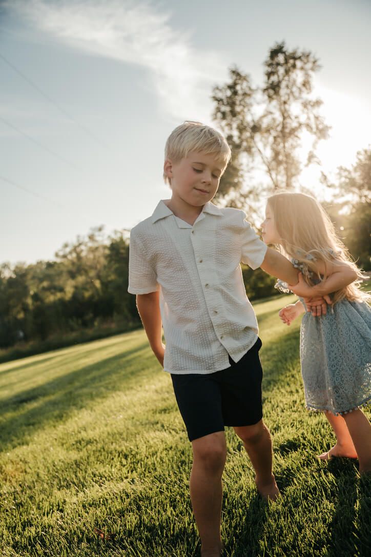 Outdoor family photography session with children siblings playing during golden hour in Omaha, Nebraska