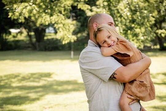 Outdoor family photography session with father and pre-schooler hugging in Omaha, Nebraska