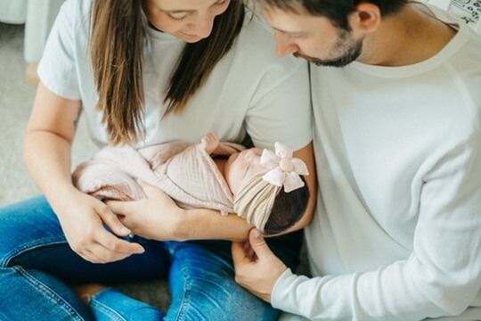 Indoor lifestyle family photography session with parents and newborn in Omaha, Nebraska