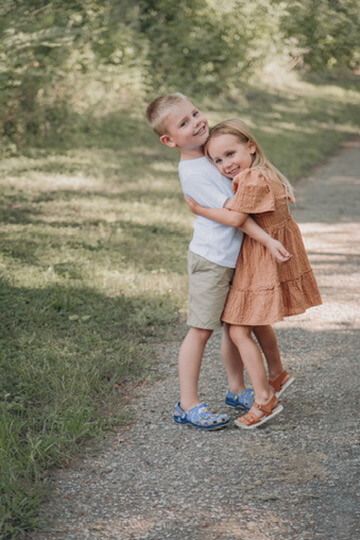 Outdoor family photography session with sibling children hugging in Omaha, Nebraska