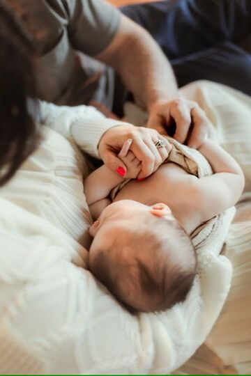 Indoor lifestyle family photography session with parents and newborn in Omaha, Nebraska