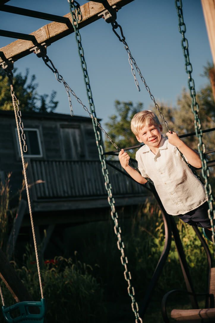 Outdoor family photography session with child on swing in Omaha, Nebraska