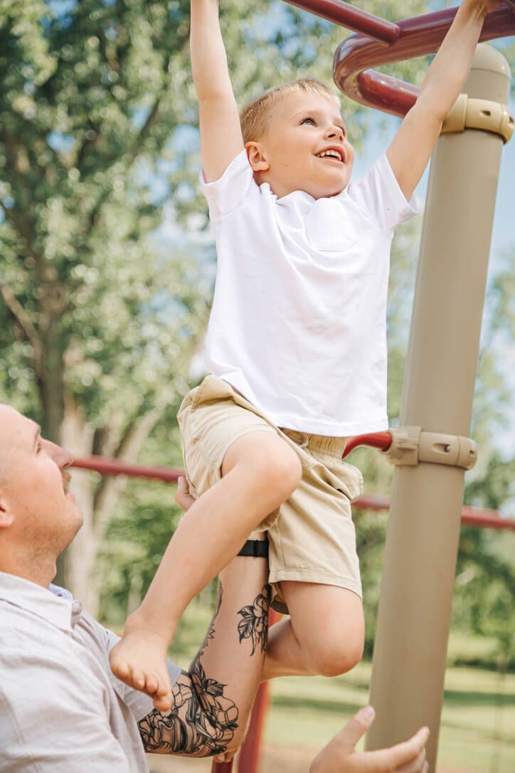 Outdoor family photography session with father and son playing at park in Omaha, Nebraska