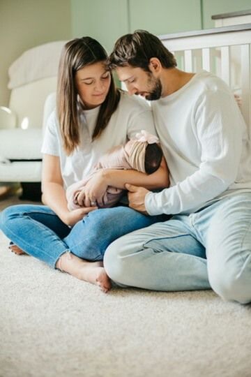 Indoor lifestyle family photography session with parents and newborn in Omaha, Nebraska