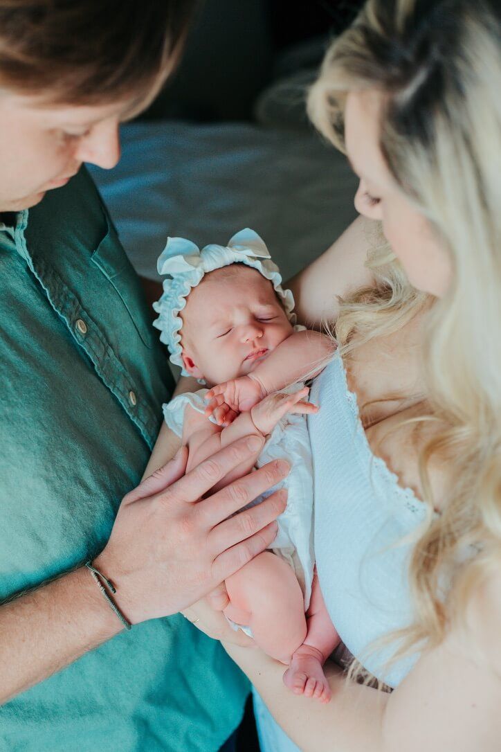Indoor lifestyle family photography session with parents and newborn in Omaha, Nebraska