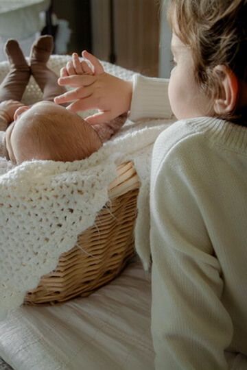 Indoor lifestyle family photography session with sister and newborn in Omaha, Nebraska