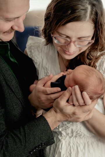 Indoor lifestyle family photography session with parents and newborn in Omaha, Nebraska